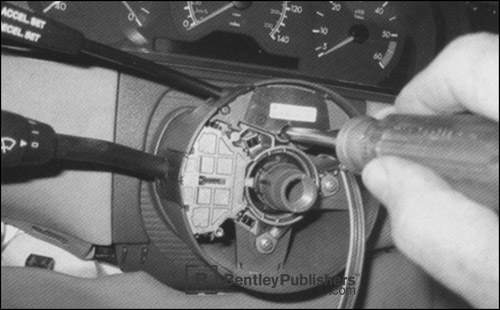 Two deeply sunk Phillips-head screws hold the copper-on-mylar contact-spiral to the steering column.